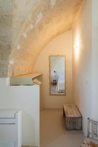 a room with a mirror and a wooden bench at Masseria Gorgognolo in Ostuni