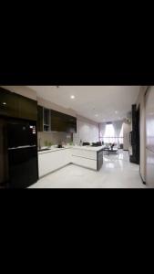 a large kitchen with white cabinets and black appliances at 8 Kia Peng Central Suites in Kuala Lumpur