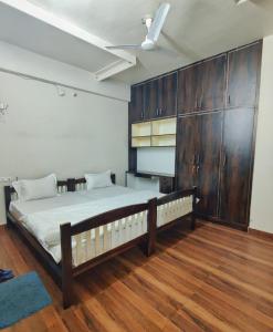 1 dormitorio con 1 cama grande y armarios de madera en Blue Door, en Bundi