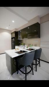 a kitchen with a island with two chairs in it at 8 Kia Peng Central Suites in Kuala Lumpur