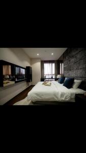 a bedroom with a large white bed with blue pillows at 8 Kia Peng Central Suites in Kuala Lumpur