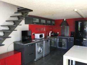 eine Küche mit roten Wänden und einer Waschmaschine in der Unterkunft Villa avec piscine, parking, clim in Palavas-les-Flots