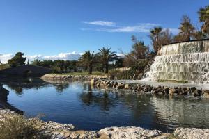 a waterfall in front of a body of water at Villa avec piscine, parking, clim in Palavas-les-Flots