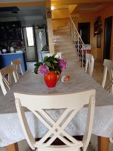 una mesa con un jarrón de flores encima en Guest House Guriani, en Grigoleti