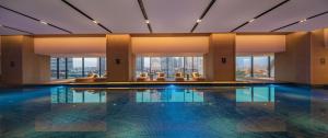 a pool in a hotel with a view of the city at Wuhan Marriott Hotel Hankou in Wuhan