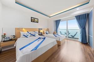 a bedroom with two beds with a view of the ocean at Blue Pearl Hotel in Nha Trang +19 photos