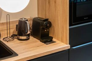 a coffee maker sitting on a counter next to a microwave at Le Loft du Parvis : spacieux, central & élégant. in Dijon