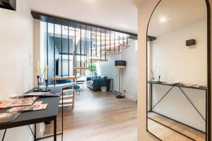 a kitchen and a living room with a table and a mirror at Le Loft du Parvis : spacieux, central & élégant. in Dijon