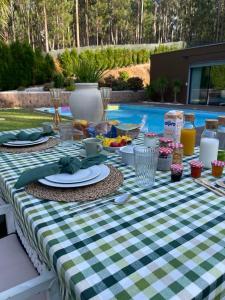 a picnic table with a green and white checkered table cloth at Villa no Jardim dos Aromas in Gião