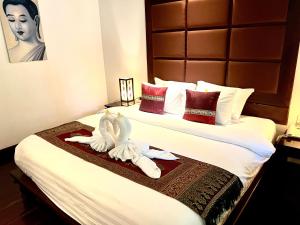 En eller flere senger på et rom på Meuangluang Hotel