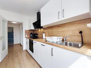 - une cuisine avec des placards blancs et un évier dans l'établissement Chic Apartment with balcony, à Bad König