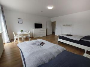 - une chambre avec 2 lits et une table avec une télévision dans l'établissement Chic Apartment with balcony, à Bad König
