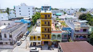 a yellow building in the middle of a city at Le Suresh Guest House in Puducherry