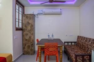 a room with a table and chairs and a couch at Le Suresh Guest House in Pondicherry