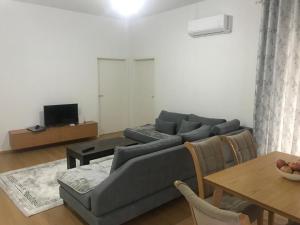 a living room with a gray couch and a table at Alban Apartment in Tirana