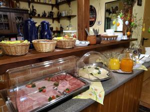 a kitchen counter with a tray of meat and orange juice at Pension Königshof 