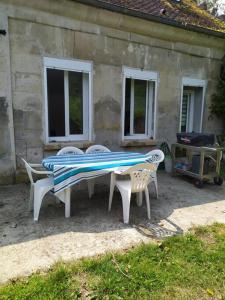 a table and chairs with a surfboard on top of it at Charmante maison dans village in Retheuil