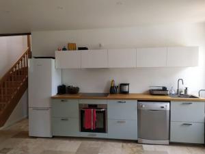 a kitchen with white cabinets and a counter top at Charmante maison dans village in Retheuil
