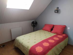 a bedroom with a bed with red pillows at Charmante maison dans village in Retheuil