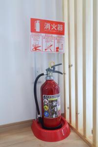 Furinkyo・楓林居 3号館 في أوساكا: صنبور ماء الحريق الأحمر مع وضع علامة عليه