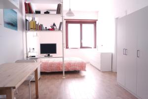 a white room with a desk and a bed and a window at CM b&b Piramide in Rome