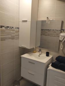 a white bathroom with a sink and a shower at ABSL Appartement in Villefranche-sur-Saône