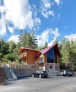 una casa con dos coches estacionados frente a ella en Arte Jermuk Cottages en Jermuk