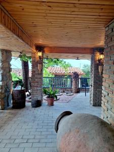 an outdoor patio with a wooden roof and a brick wall at Kadori Hills in Tʼelavi