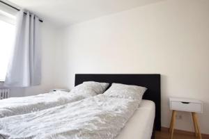 een slaapkamer met 2 witte bedden en een raam bij Air Apartments 13 in Bremen