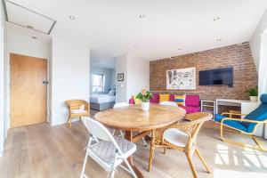 comedor y sala de estar con mesa y sillas en Whitechapel, Fantastic 1Bed Apt with Stunning Views over City en Londres