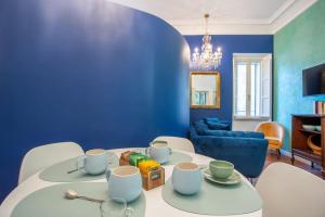 een woonkamer met een witte tafel en een blauwe muur bij PgRhome Luxury Apartments Colosseo 11 BLU in Rome