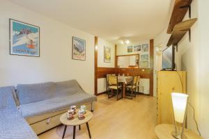 ein Wohnzimmer mit einem Sofa und einem Tisch in der Unterkunft Chamonix Sud - Jonquilles 25 - Happy Rentals in Chamonix-Mont-Blanc