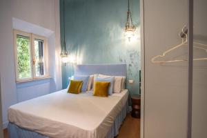 een blauwe slaapkamer met een bed met gele kussens bij PgRhome Luxury Apartments Colosseo 11 BLU in Rome