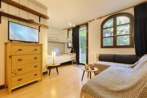 ein Wohnzimmer mit einem TV und ein Schlafzimmer in der Unterkunft Chamonix Sud - Jonquilles 25 - Happy Rentals in Chamonix-Mont-Blanc