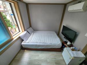 a small bedroom with a bed and a window at e comfy Hotel in Ulleung