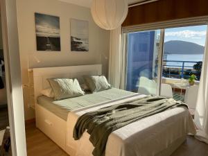 a bedroom with a large bed and a large window at Apartamento con vistas al mar B3 Urb Puerto Azul in Cedeira +10 photos