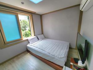 a small bedroom with a bed and a window at e comfy Hotel in Ulleung