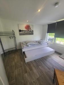 een witte kamer met een bed en een raam bij Ruhiges Apartment mit Blick in den Garten in Alsdorf