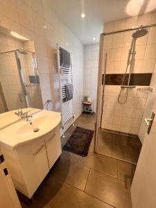 a white bathroom with a shower and a sink at Alsdorf 3 in Alsdorf