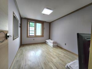 an empty room with a wooden floor and a window at e comfy Hotel in Ulleung +15 photos