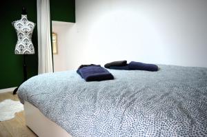 Schlafzimmer mit einem Bett mit blauer Bettwäsche und einer Puppe in der Unterkunft Le Gambetta, 100m de la plage in Luc-sur-Mer