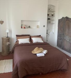 a bedroom with a large bed with a hat on it at Le Jardin D'Elma in Vence