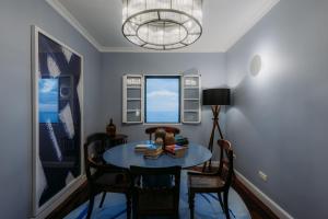 a dining room with a table and chairs and a chandelier at Quinta São Gonçalo in Funchal