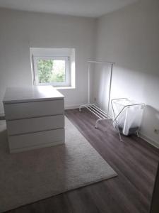 a white room with a dresser and a window at Appartement 2 chambres à Theux in Theux