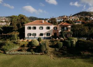 uma grande casa branca com um jardim em Quinta São Gonçalo no Funchal