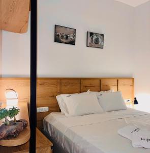 een slaapkamer met een bed met twee foto's aan de muur bij Majestic Mykonos in Ornos