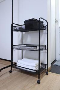 a black towel rack with white towels on it at Furinkyo・楓林居 5号館 in Osaka