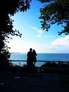 um homem e uma mulher de pé em frente ao oceano em Villa Maree em Pipa