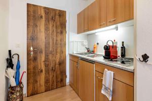 una cucina con lavandino e porta in legno di Derby 26A a Arosa