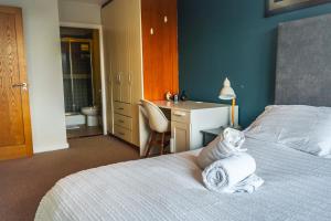 a bedroom with a bed and a desk and a bathroom at Stunning Modern Apartment in the Gasworks in Dublin